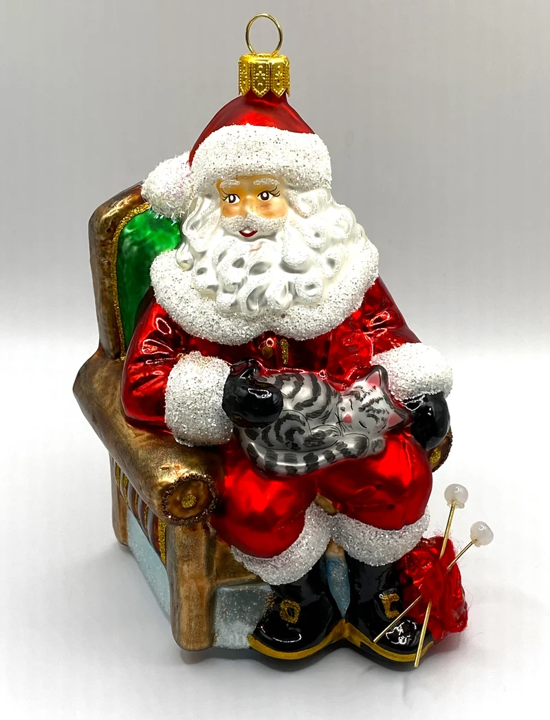 Der Weihnachtsmann macht mit der Katze auf dem Schoss eine Pause vom Stricken