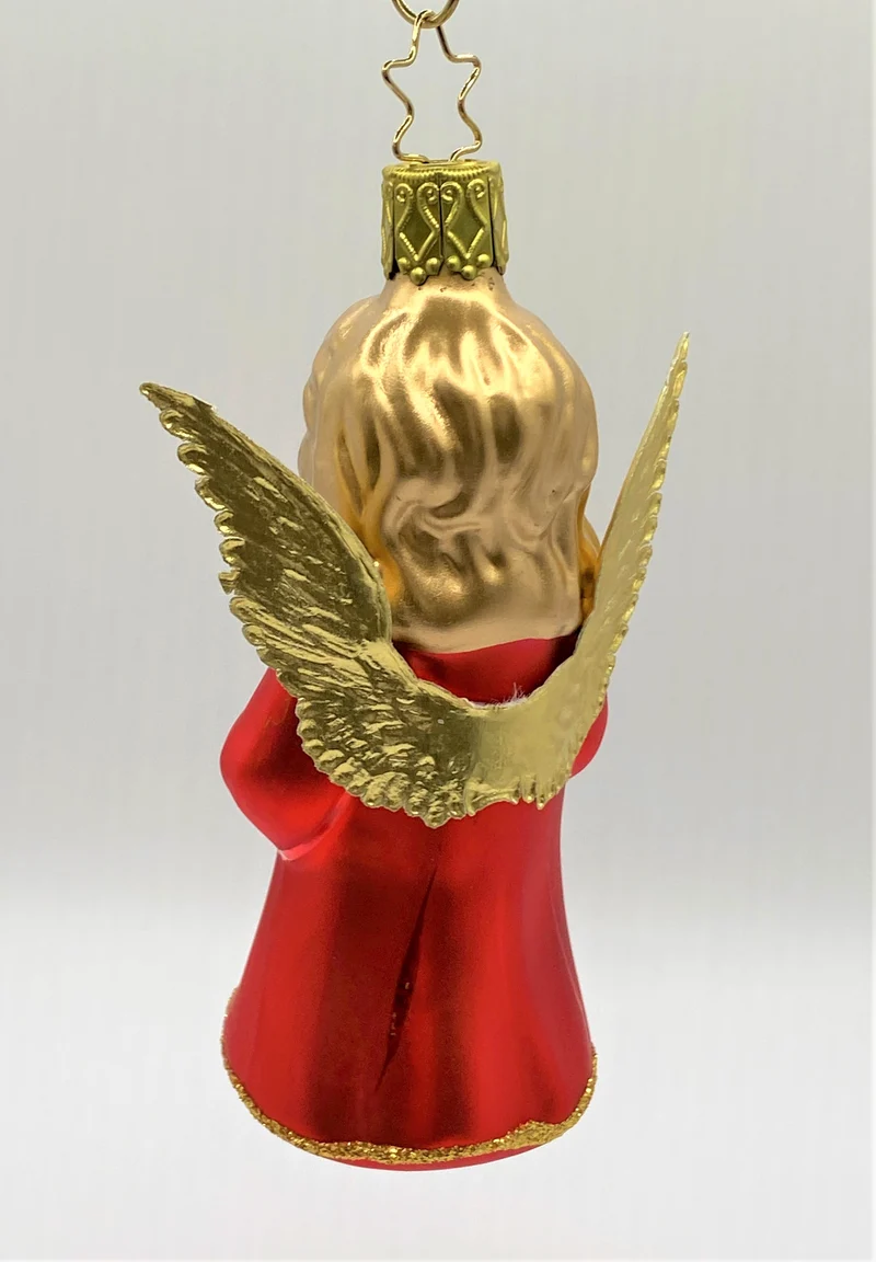 Betender Engel im roten Kleid mit goldenen Flügeln