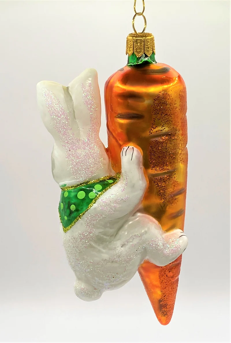 Weisser Osterhase klettert an der Karotte