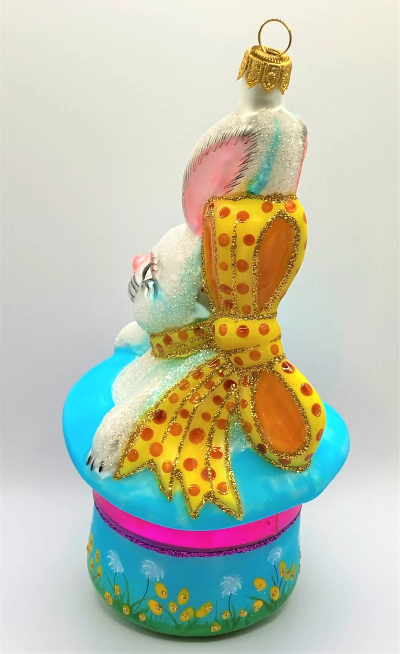 Weisser Osterhase sitzt im bunten Frühlings - Hut
