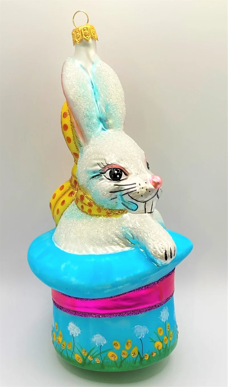 Weisser Osterhase sitzt im bunten Frühlings - Hut