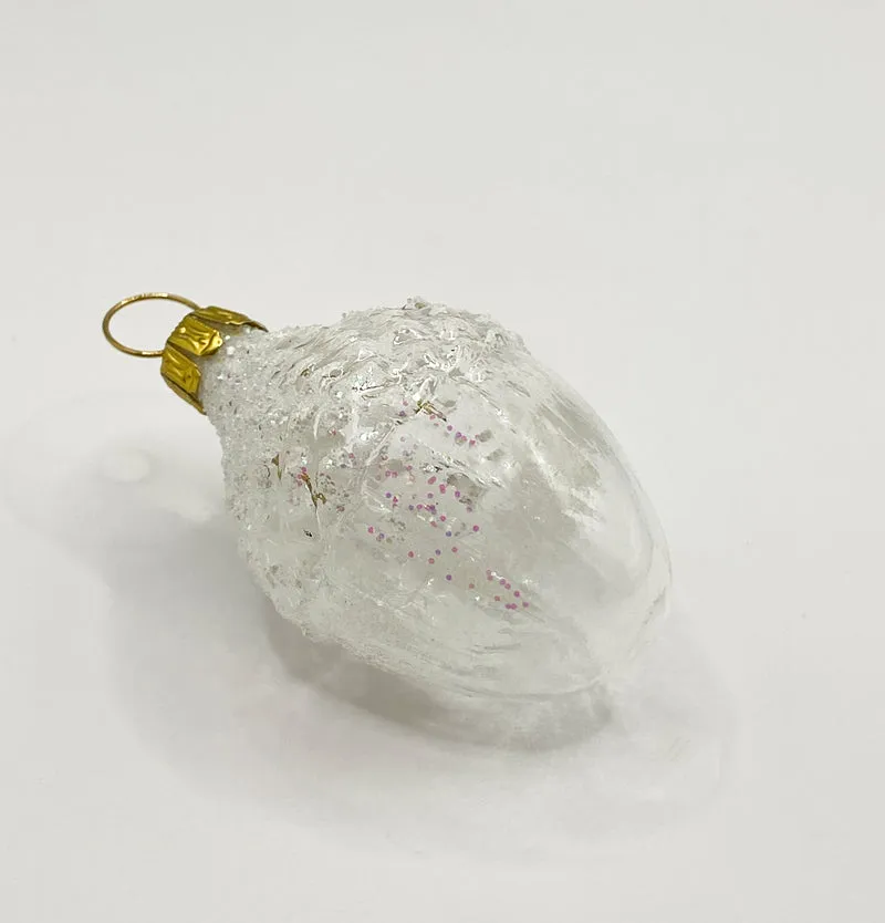 Verschneite transparente Eichel mit irisierendem Glitzer