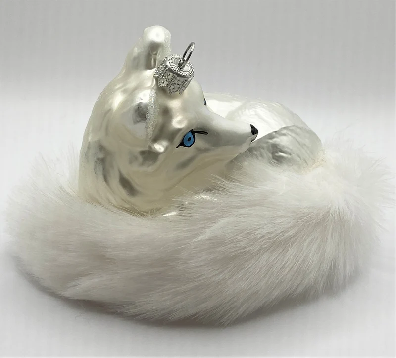 Liegender Polarfuchs mit buschigem Schwanz