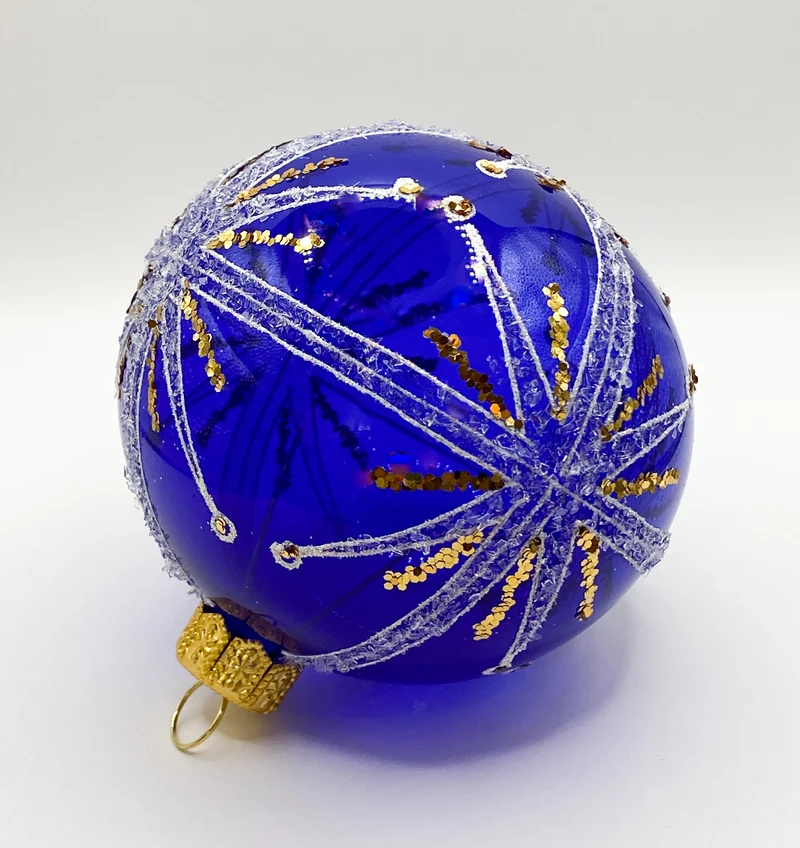 Transparente blaue Kugel mit weissem und goldenem Sternendekor