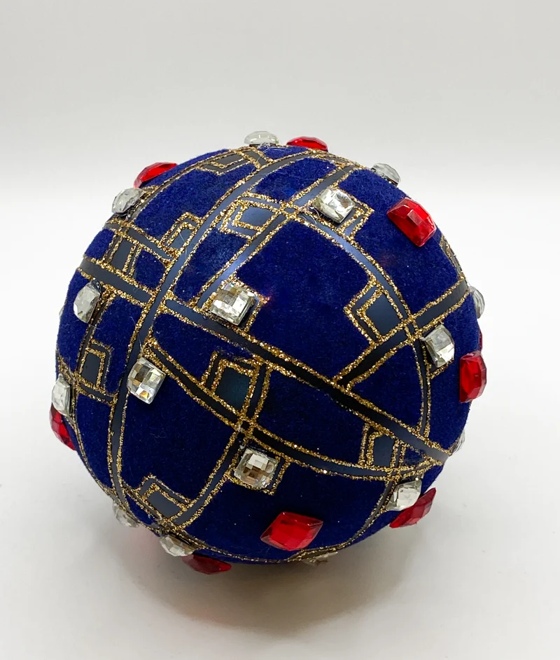Samtig blaue Kugel mit roten und silbernen Schmucksteinen