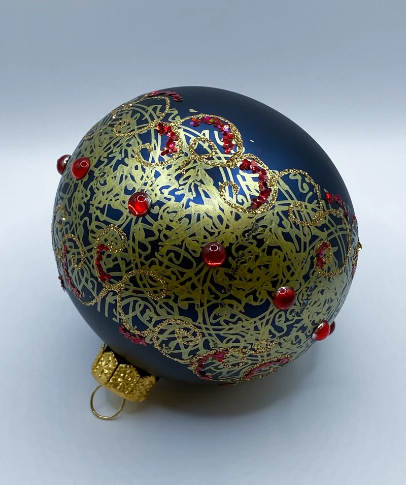 Dunkelblaue Kugel mit goldenem Dekor und roten Schmucksteinen