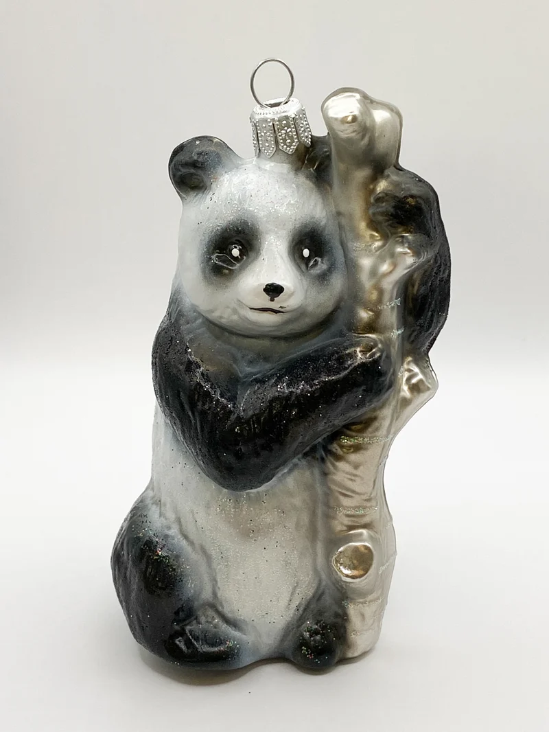 Pandabär klettert am Baumstamm
