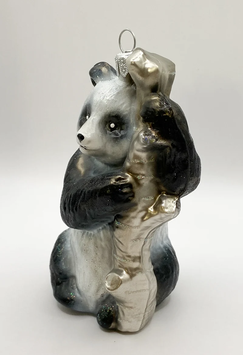 Pandabär klettert am Baumstamm