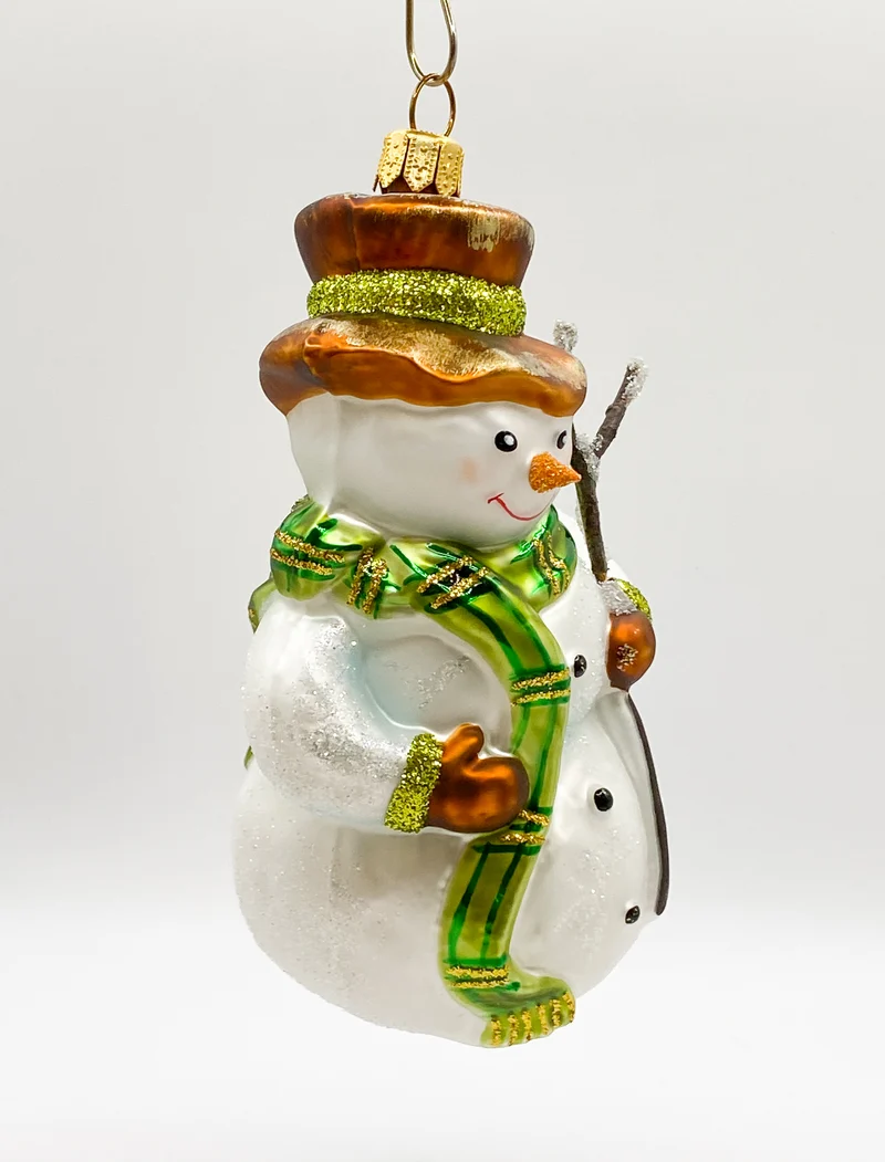Schneemann mit grünem Schal und Reisig-Stecken