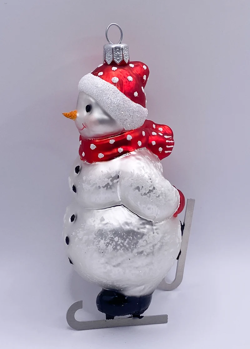 Schneemann Schlittschuh fahrend mit roter Mütze