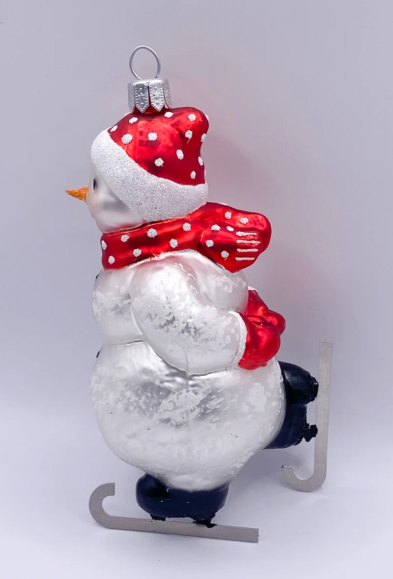 Schneemann Schlittschuh fahrend mit roter Mütze