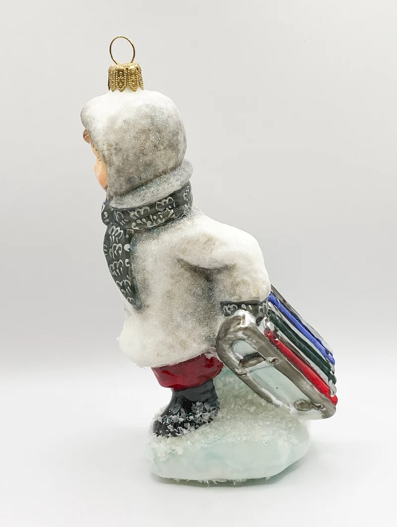 Der kleine Junge stapft mit dem Schlitten durch den Schnee, AtlasArt