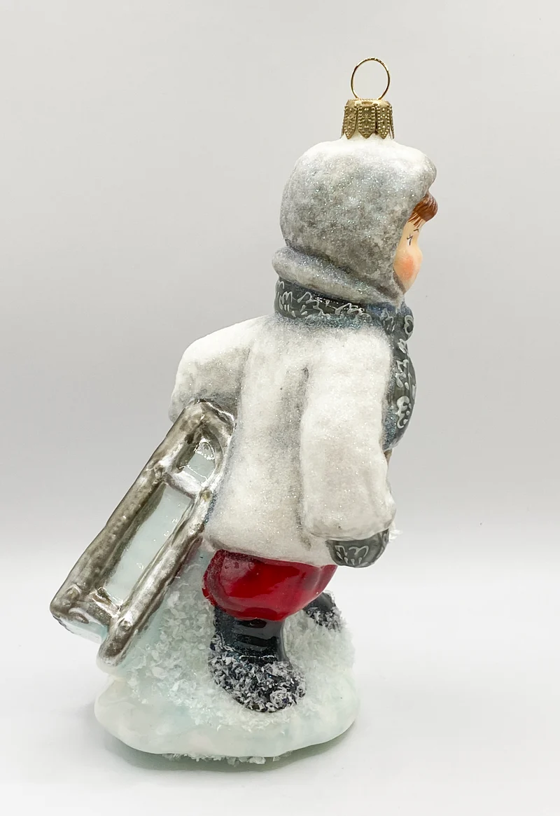 Der kleine Junge stapft mit dem Schlitten durch den Schnee, AtlasArt