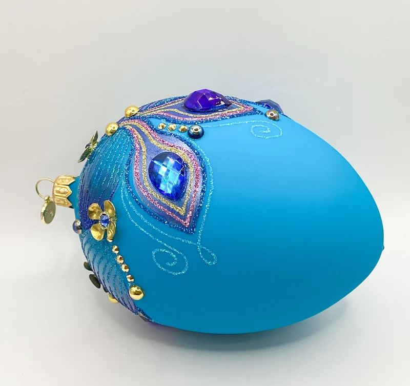Eiform türkis mit blauen und violetten Schmucksteinen und metallenen Blüten Applikationen, GlitterLa