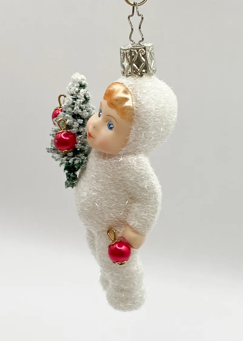 Schneekind mit dem geschmückten Christbäumchen