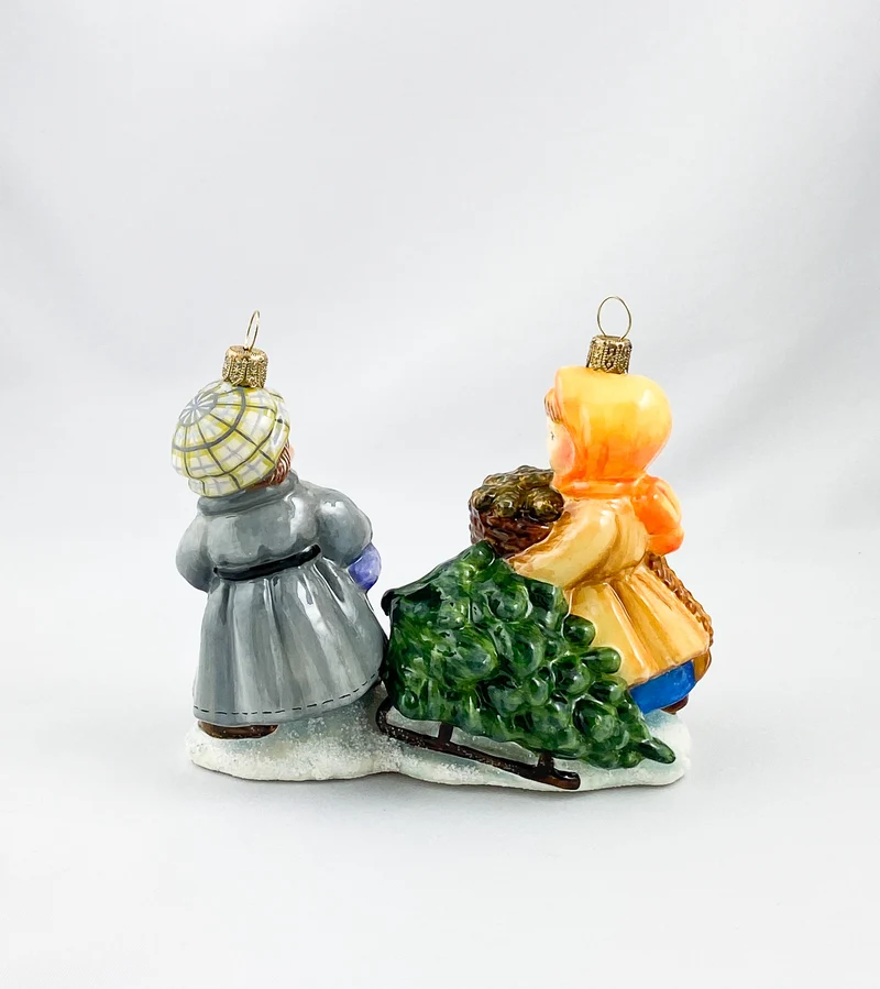 Das Mädchen und der Junge holen den Weihnachtsbaum mit dem Schlitten aus dem Wald, AtlasArt
