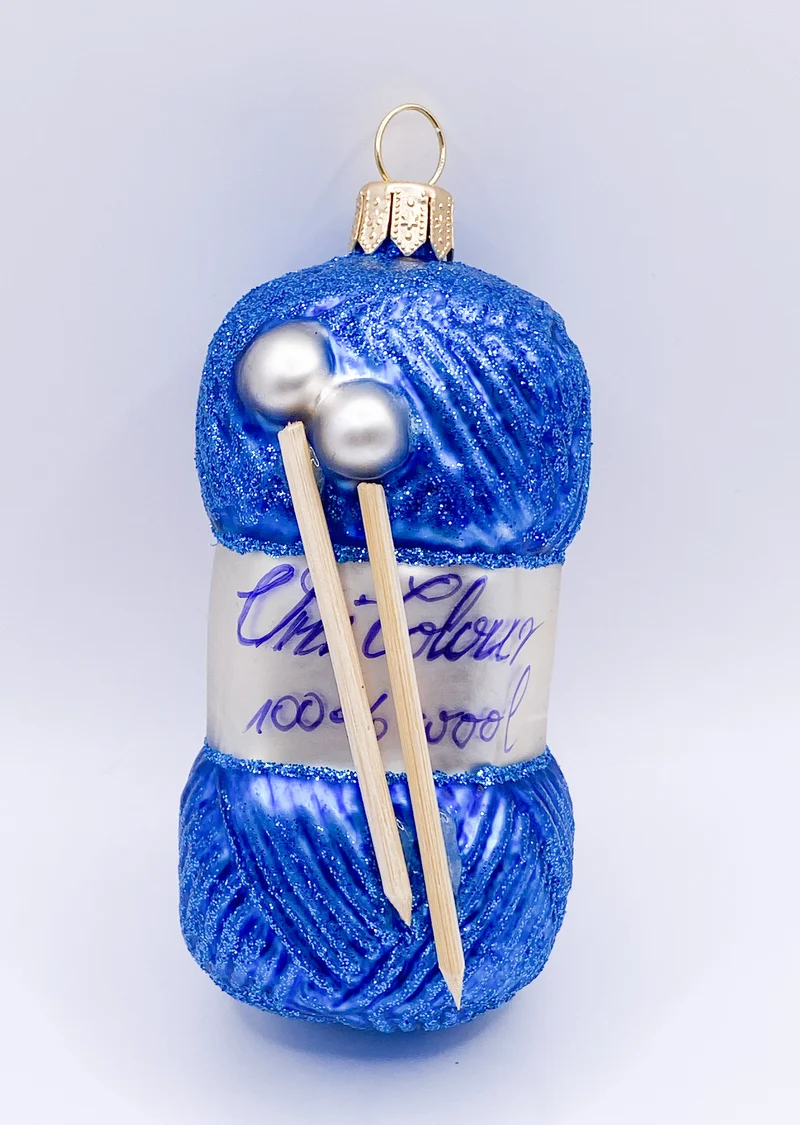 Blauer Wollknäuel mit Stricknadeln