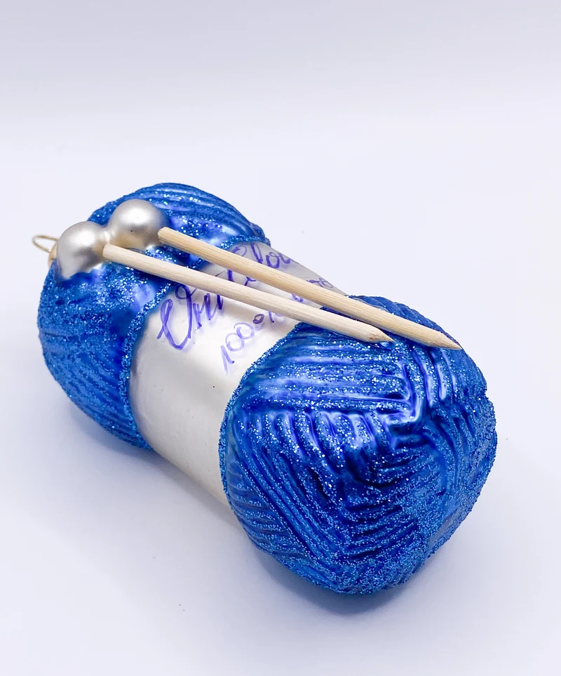 Blauer Wollknäuel mit Stricknadeln