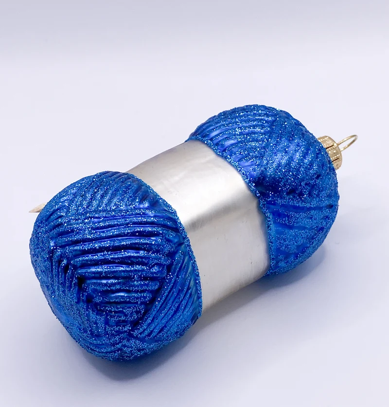 Blauer Wollknäuel mit Stricknadeln
