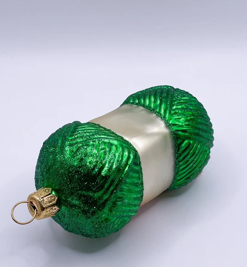 Grüner Wollknäuel mit Stricknadeln