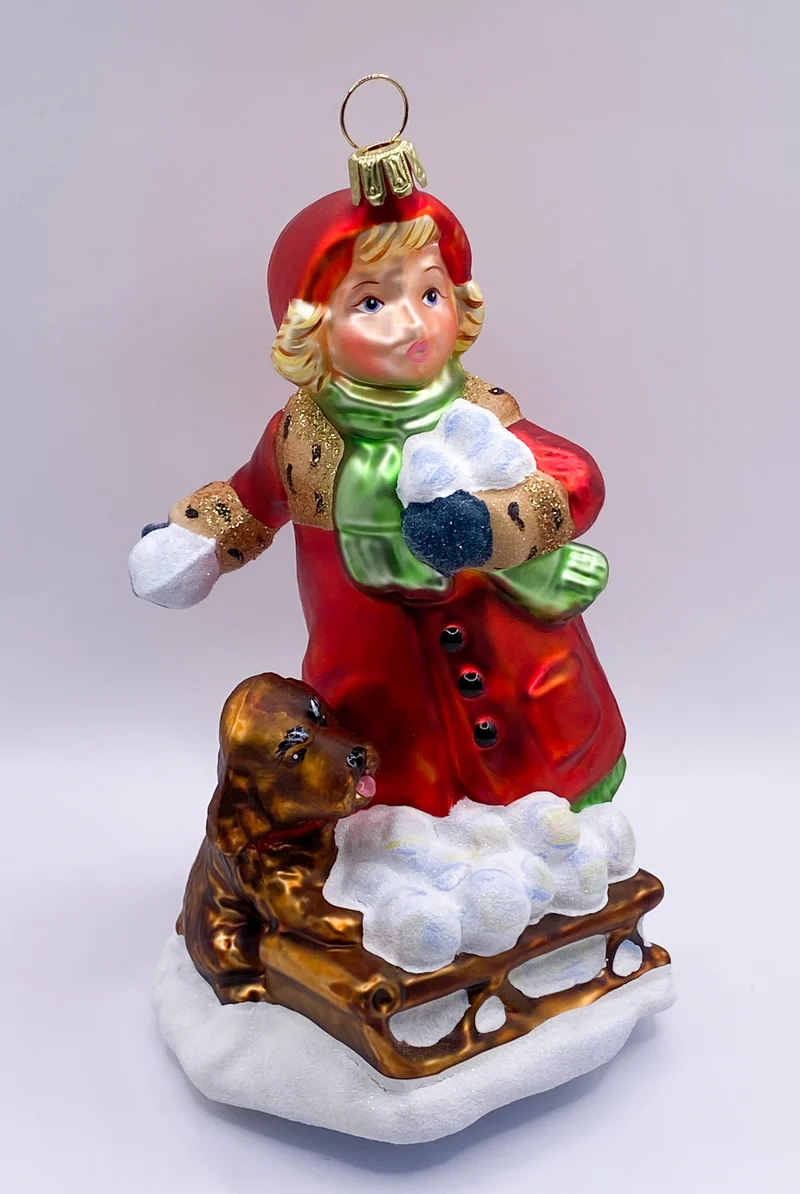 Das Mädchen macht mit dem Hund eine Schneeball-Schlacht KOMOZJA MOSTOWSKI