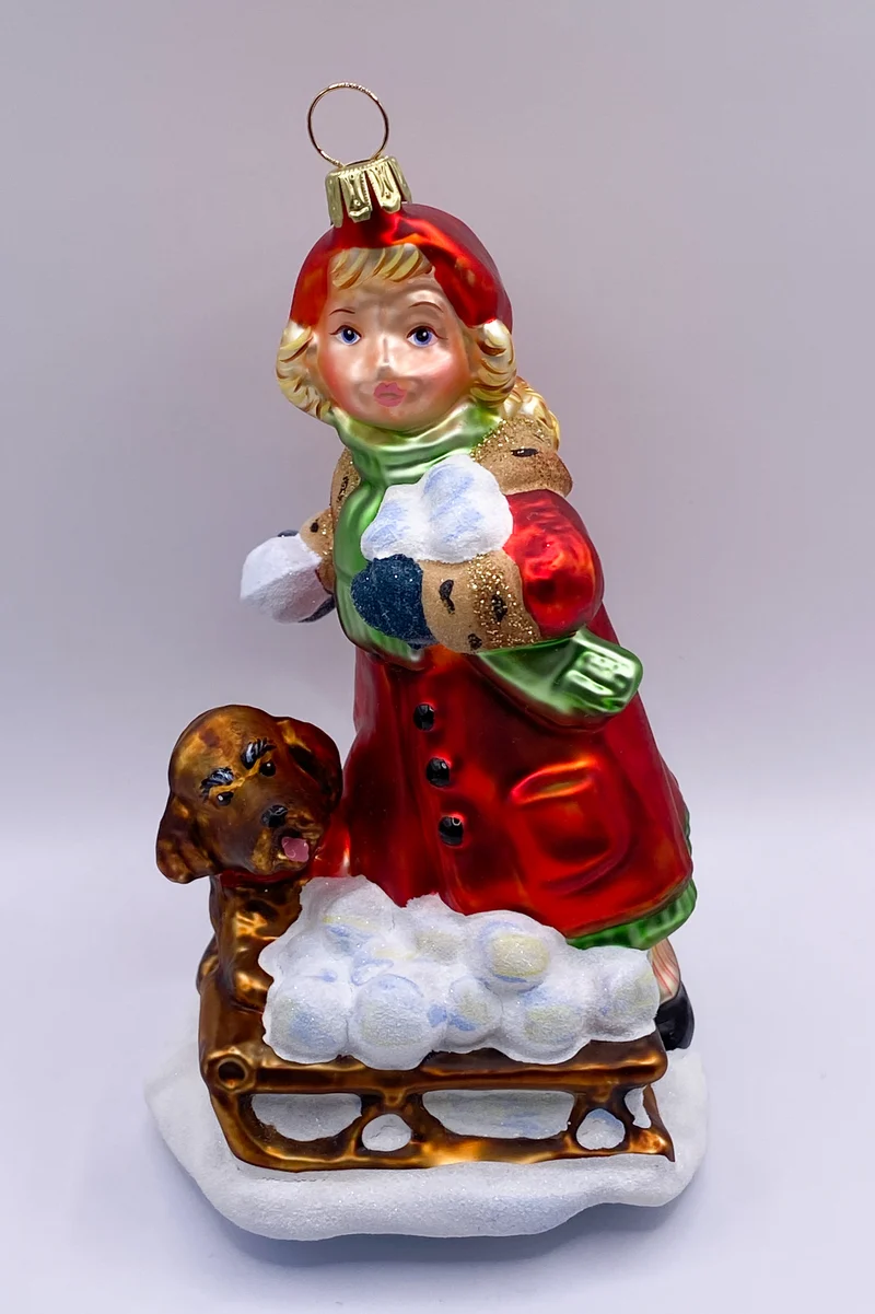 Das Mädchen macht mit dem Hund eine Schneeball-Schlacht KOMOZJA MOSTOWSKI